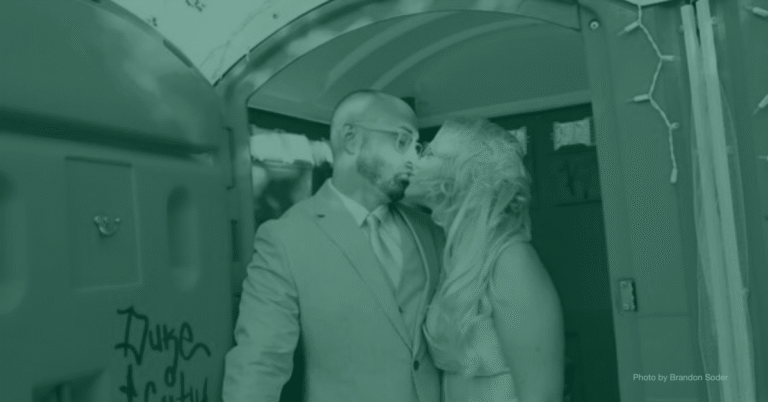 Newlyweds kissing just inside a portable restroom unit after their wedding portable toilets for weddings